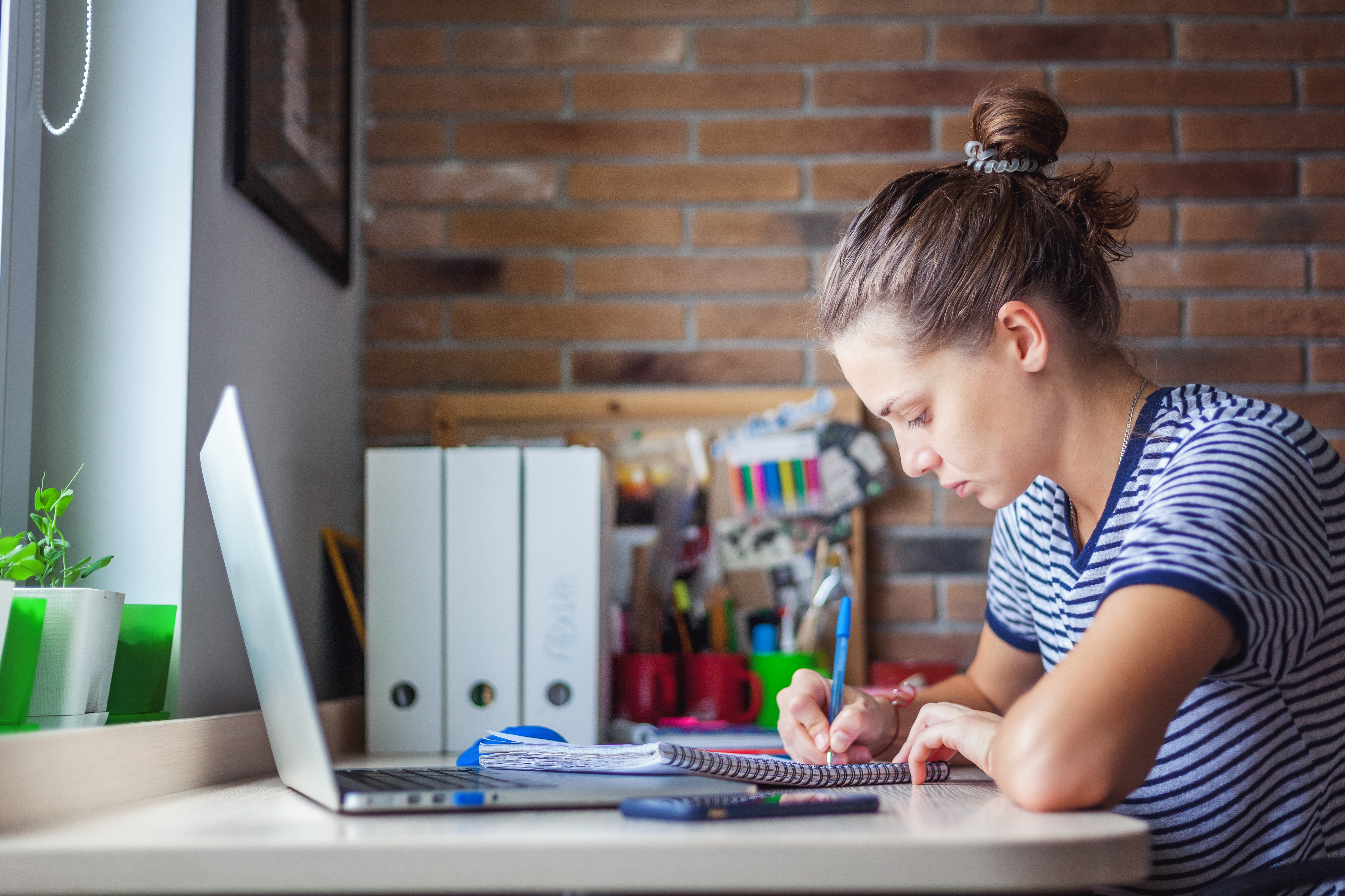 Student online care lucrează la laptopul ei