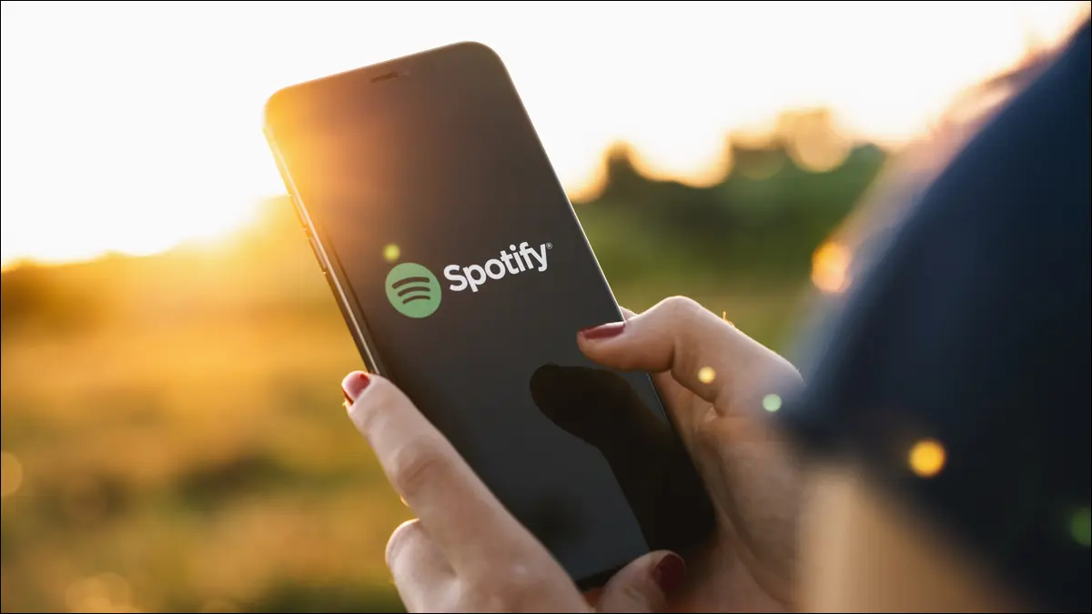 Человек, использующий смартфон с логотипом Spotify на нем