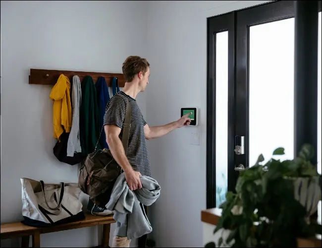 Mann mit Touchscreen-Panel an der Haustür