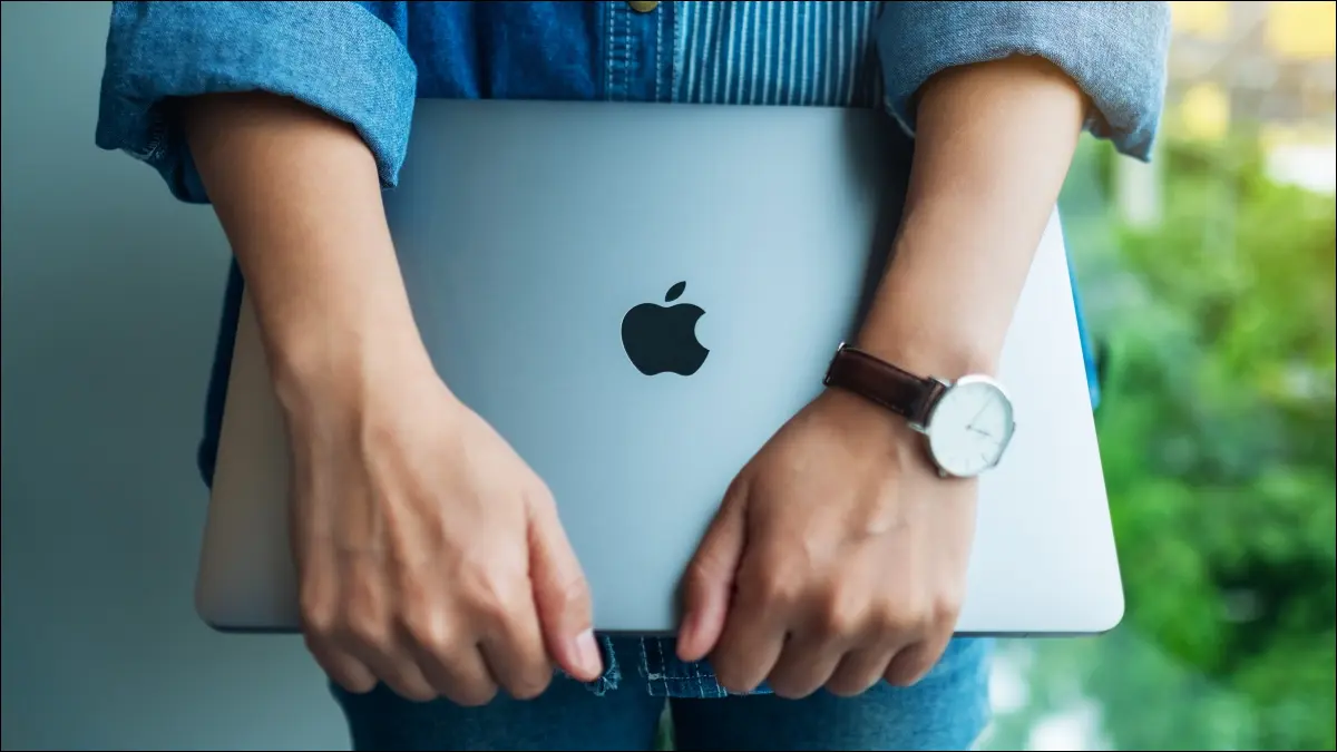 Una donna con in mano un Apple MacBook Pro.