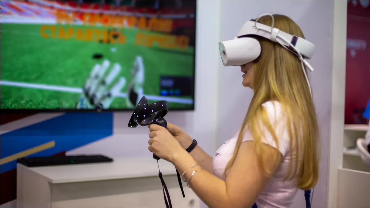 Seorang wanita bermain game di headset Windows Mixed Reality VR.