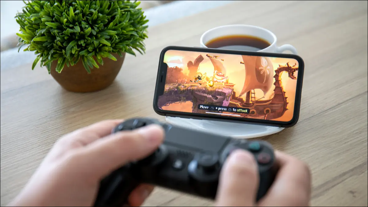 Seseorang memainkan game iPhone dengan pengontrol DualShock.