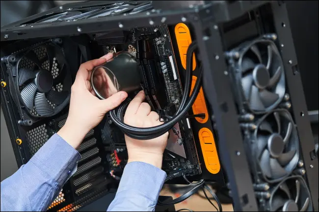 Bir PC'ye sıvı soğutma takan bir kişi.