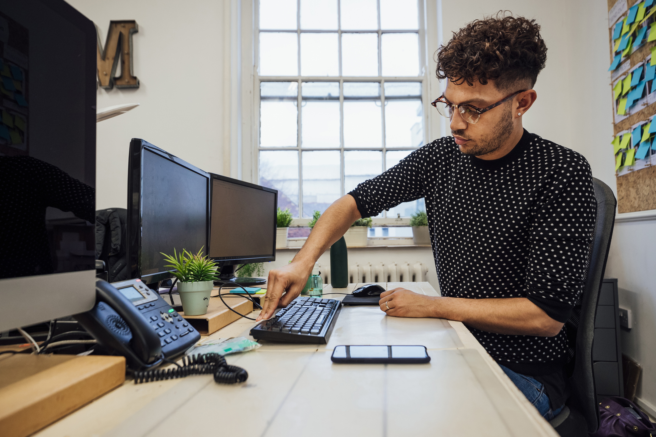 デスクトップコンピュータのキーボードを掃除する男