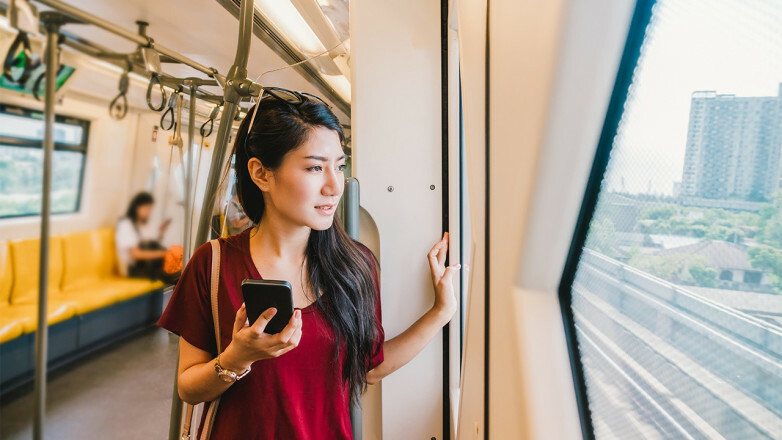 火車車上的女人拿著電話望著窗外