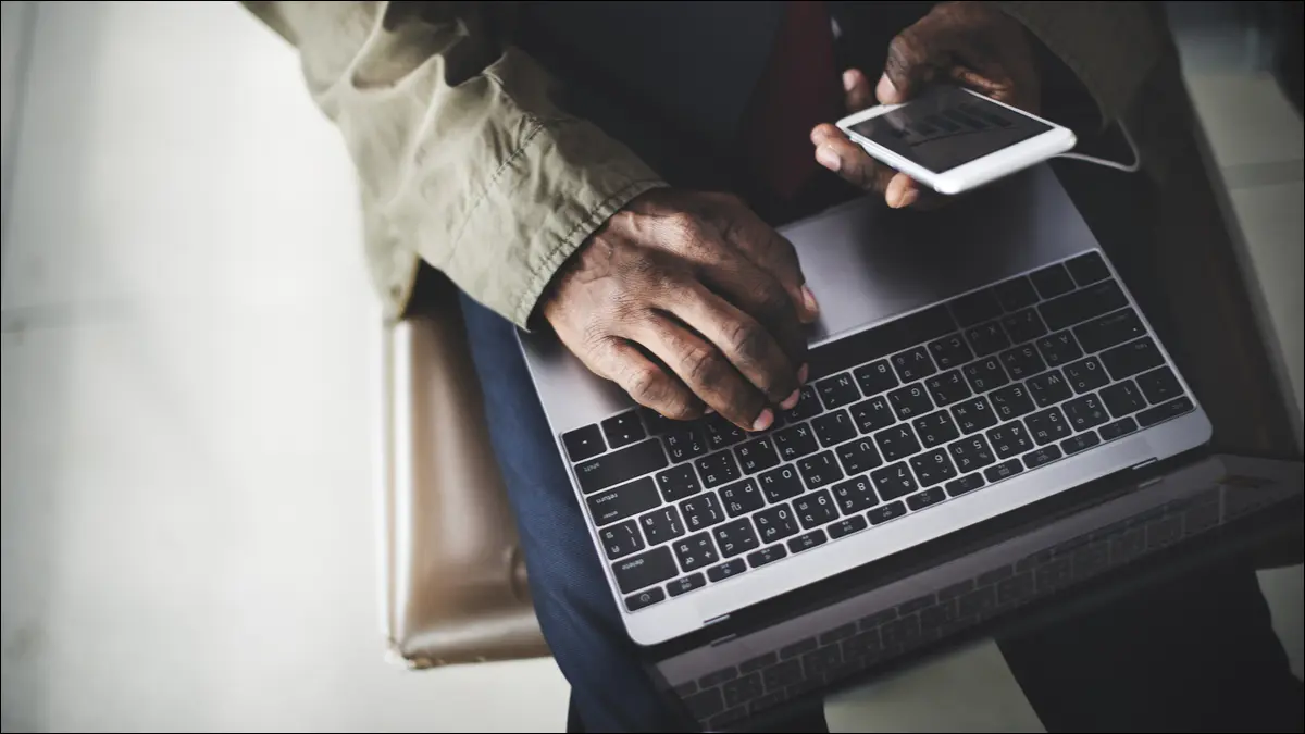 Pendler mit Smartphone und Laptop zusammen.