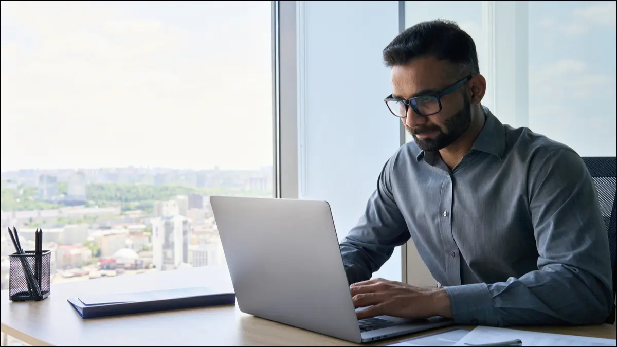 personne travaillant sur un ordinateur portable dans un bureau de grande hauteur