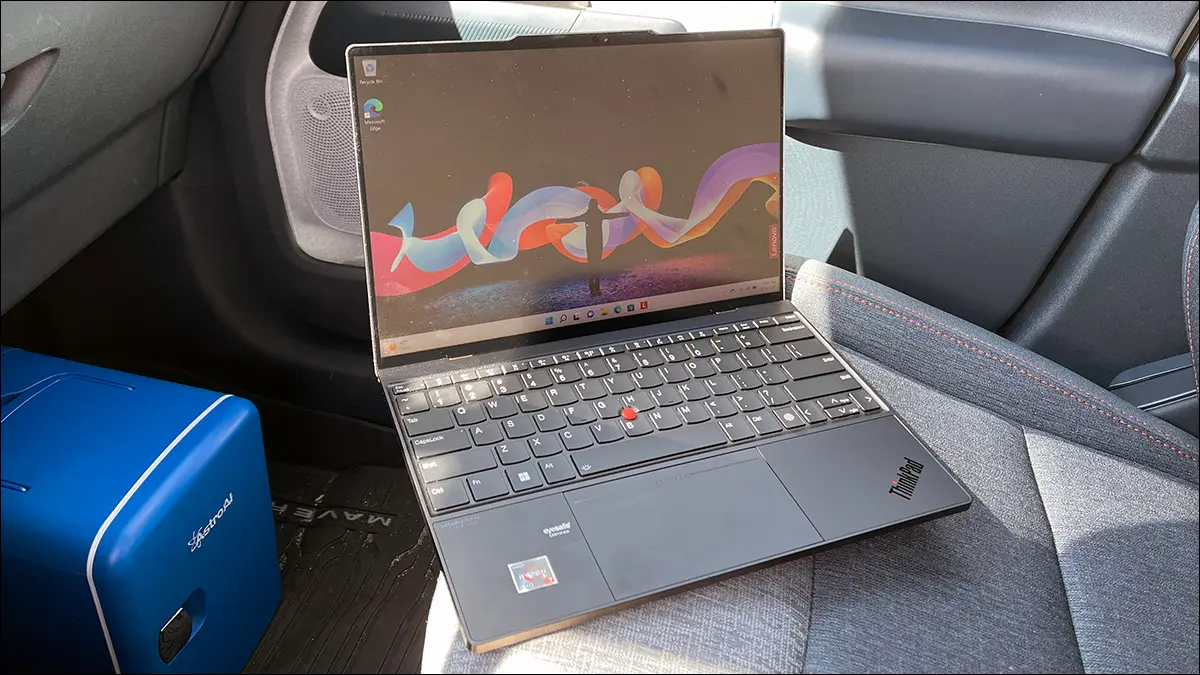 Un notebook touchscreen Lenovo ThinkPad Z13 Gen 1 aperto all'interno di un'auto in una giornata di sole