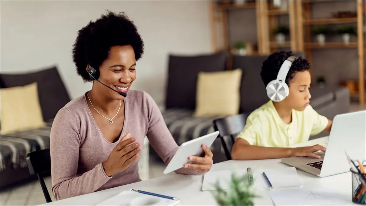 ヘッドセットを使用してタブレットとラップトップで音声チャットを行う女性と子供。