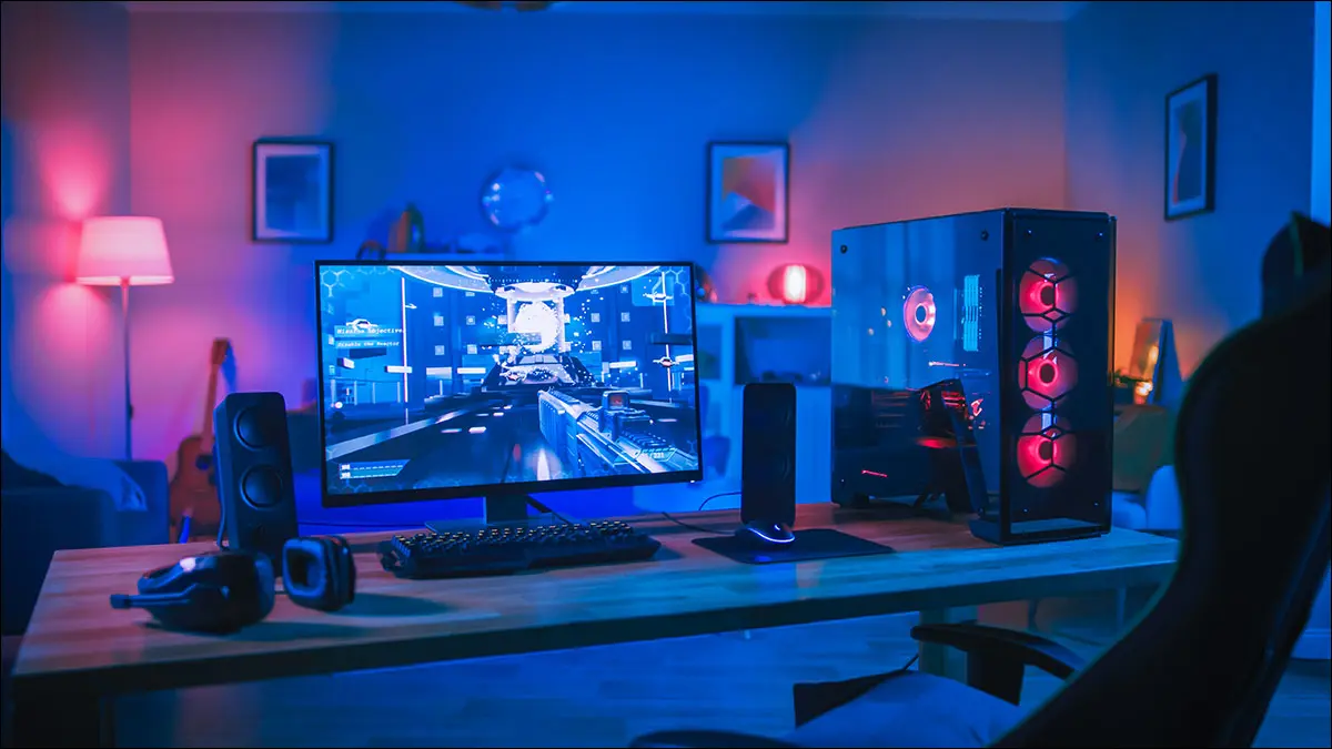 Una PC para juegos en una habitación iluminada con luces de colores.