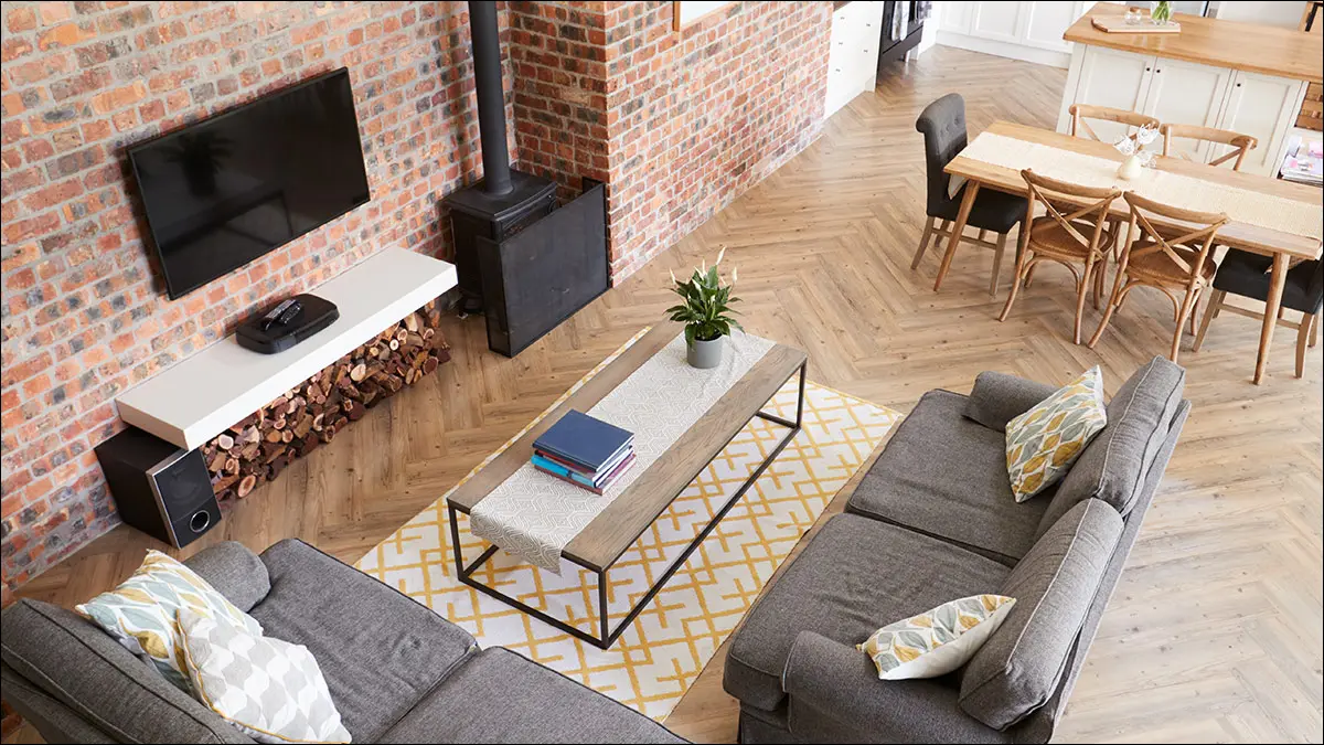 Un salon spacieux de style loft avec des murs en briques.