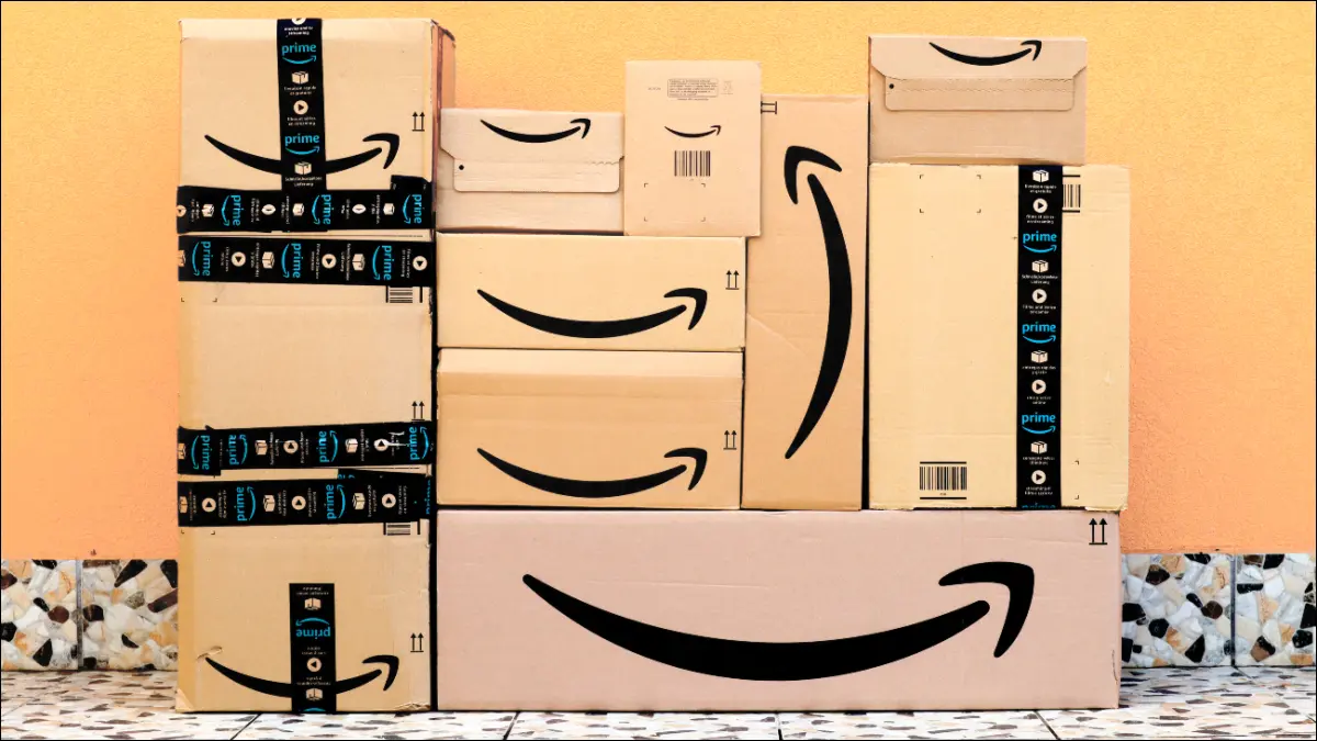 Cajas de Amazon apiladas frente a una pared amarilla