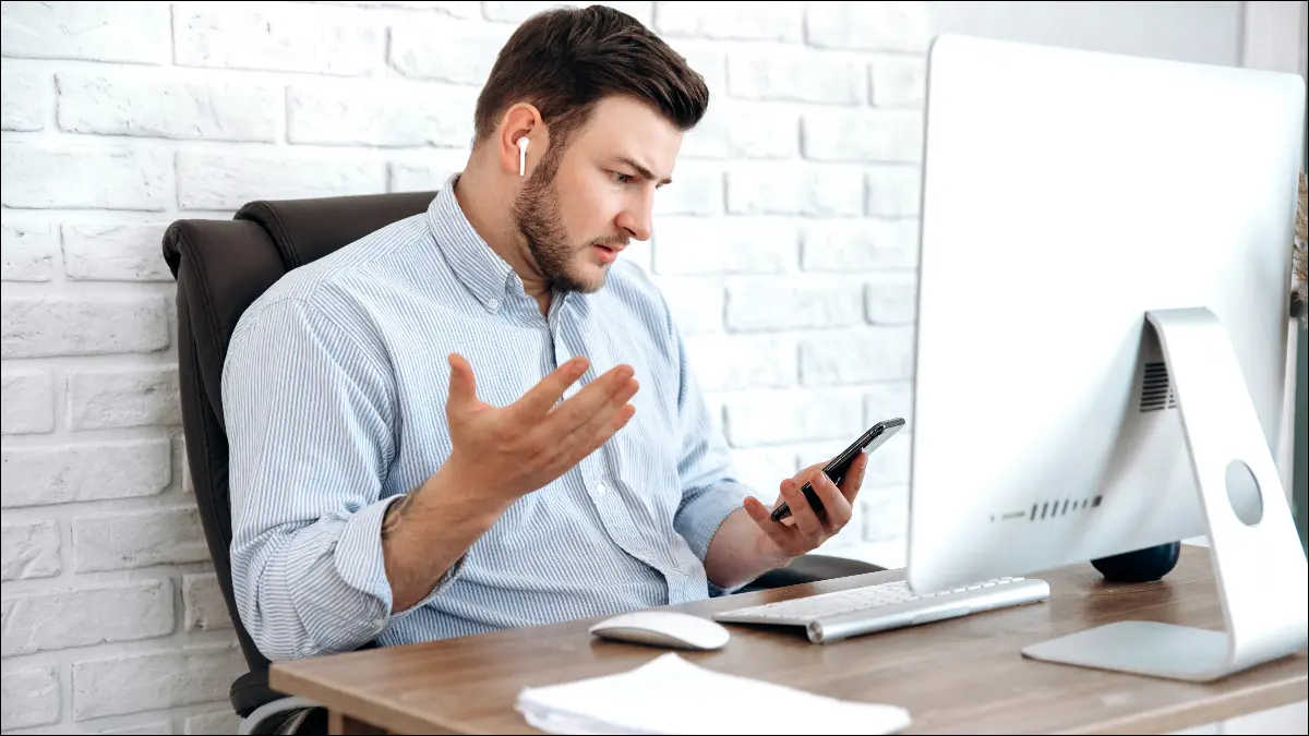 Hombre usando AirPods y mirando su iPhone con sorpresa