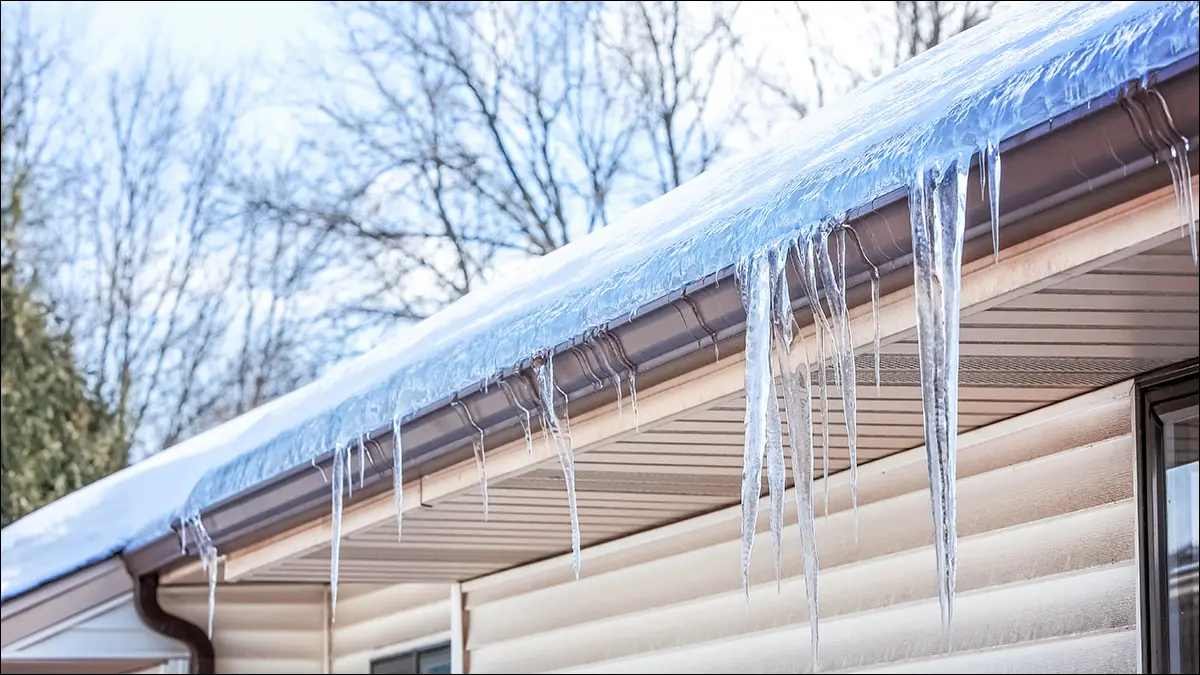 Un barrage de glace construit le long de la gouttière d'une maison.