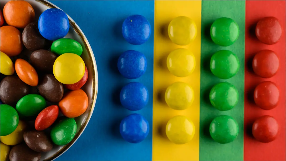 Bonbons colorés triés par couleur en rangées.