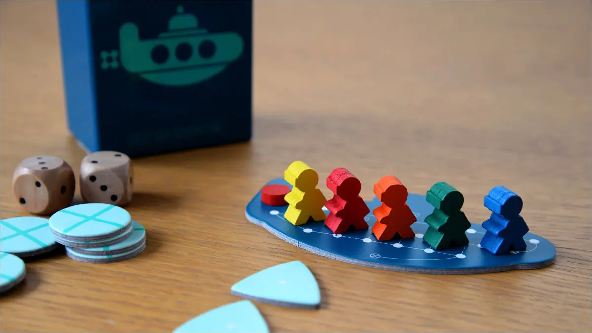 Un submarino de cartón con pequeños modelos de jugadores de madera del juego Deep Sea Adventure.