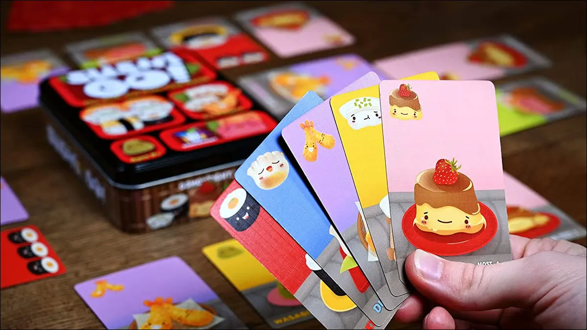 Un jugador con una colorida mano de cartas con temas de sushi del juego Sushi Go.