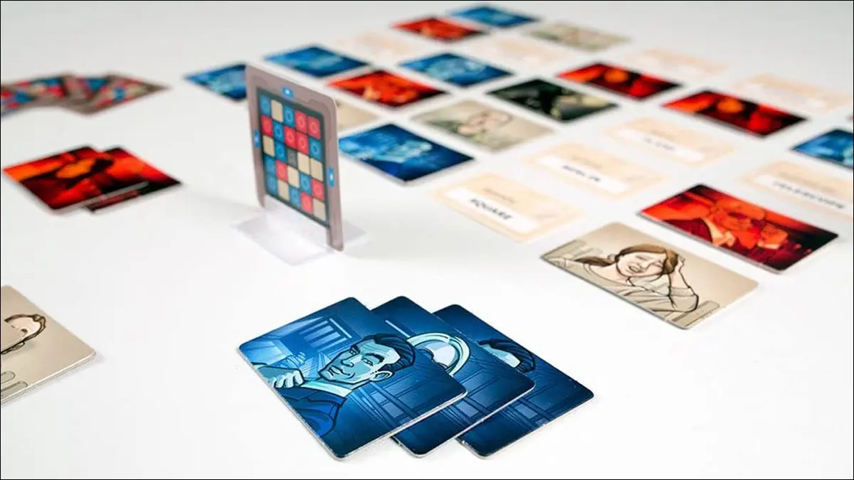 Las fichas y las cartas del juego Codenames están esparcidas sobre una mesa.