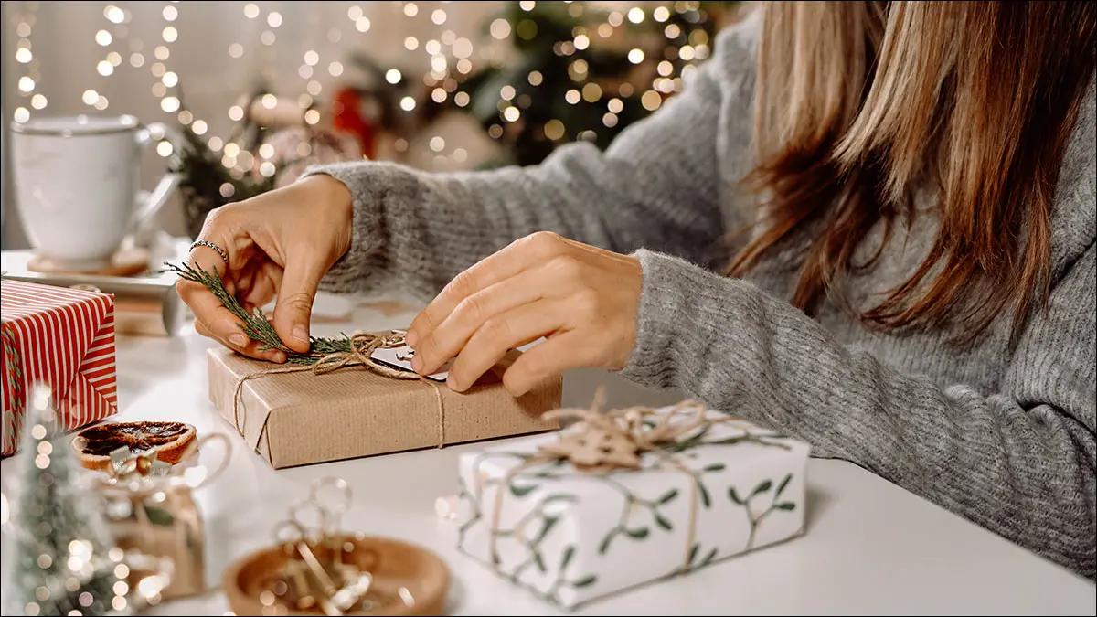 Une personne emballant un cadeau symbolique à associer à un code numérique.