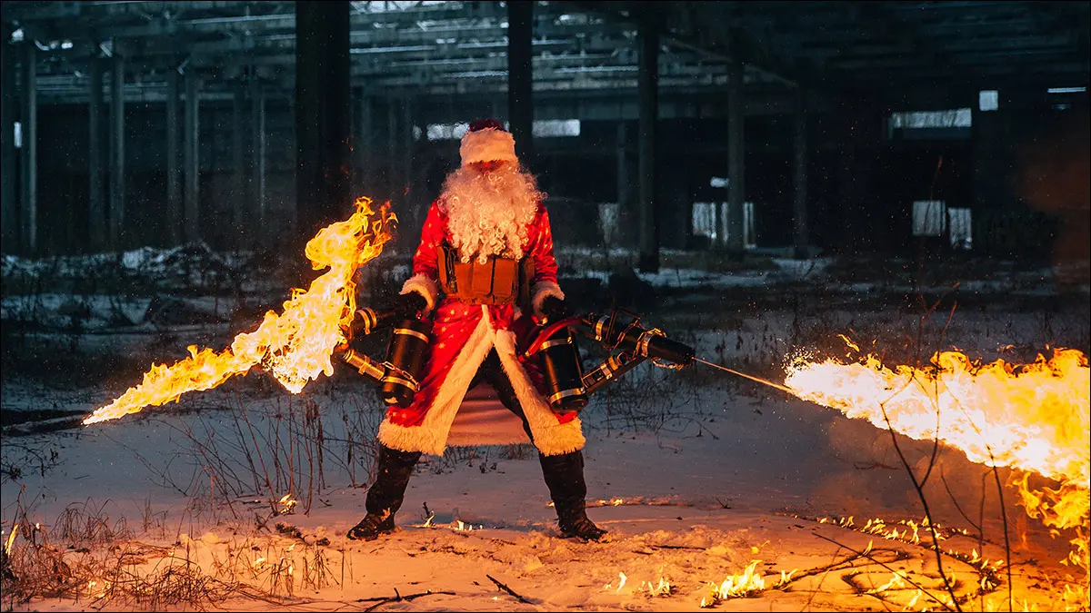 Papá Noel, dos lanzallamas, derritiendo nieve a la sombra de un gran almacén.