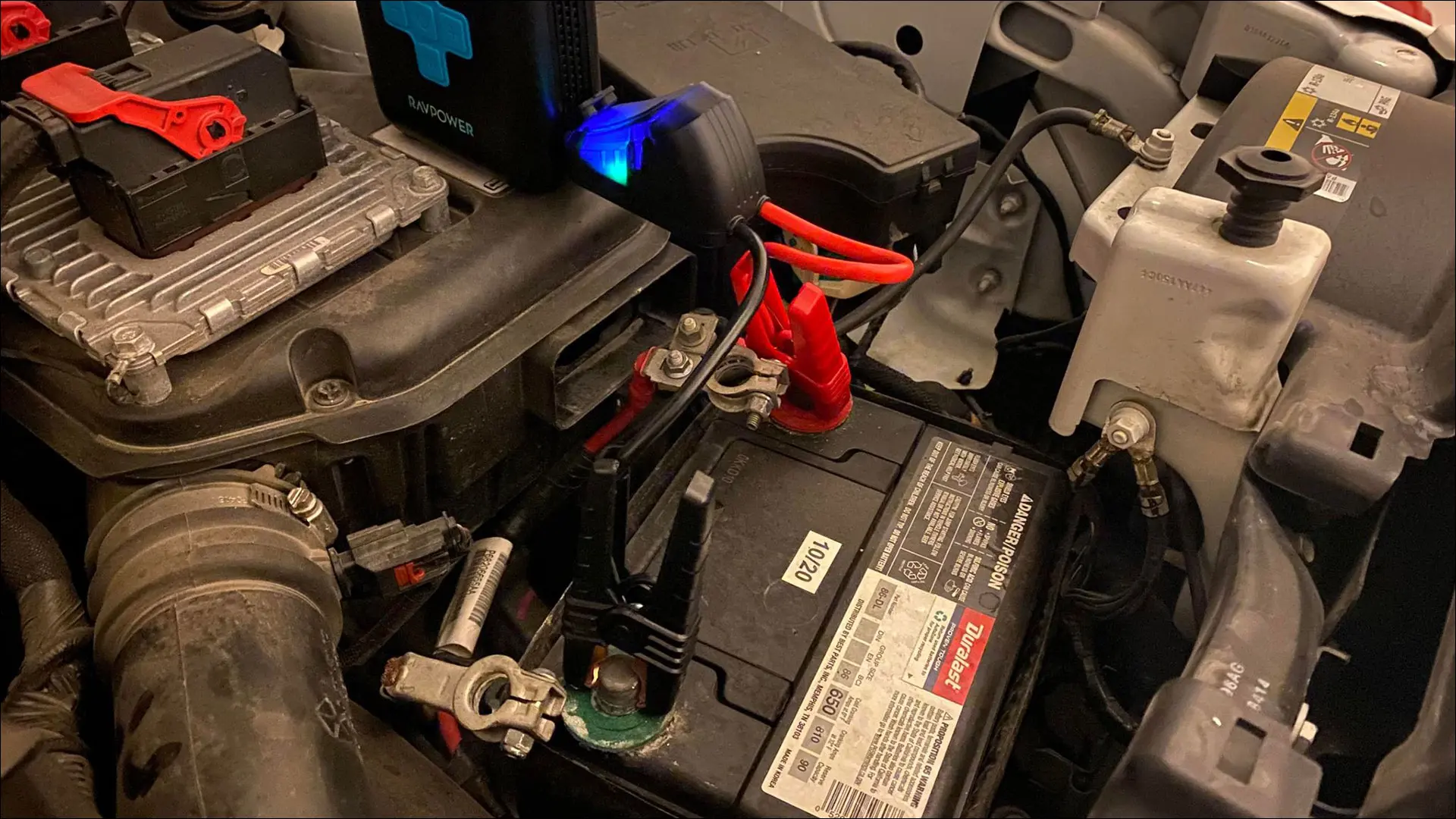 RAVPower Jump Starter connecté à une batterie de voiture avec un voyant bleu positif