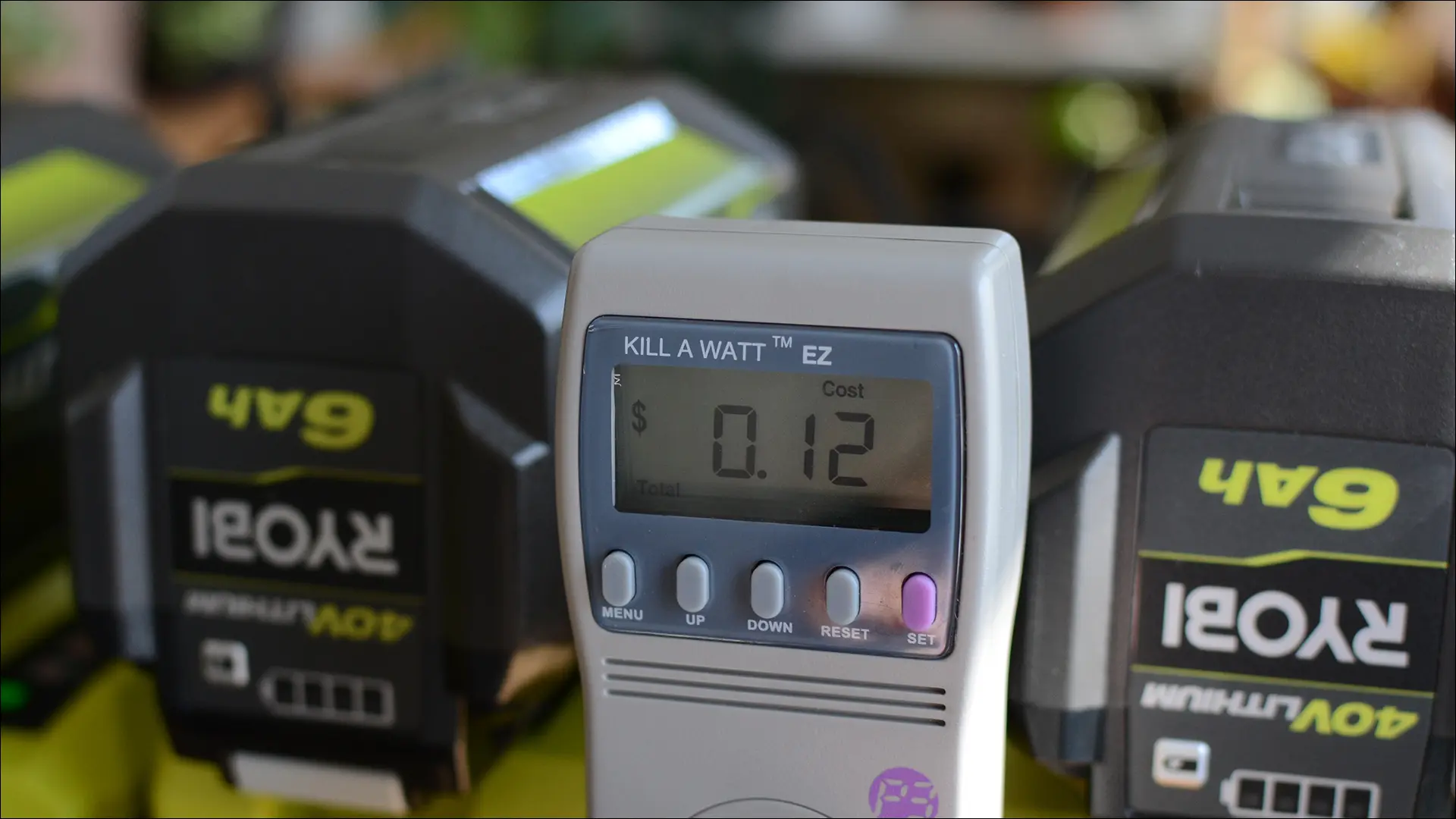 Vue rapprochée d'un compteur Kill A Watt chargeant des batteries Ryobi.