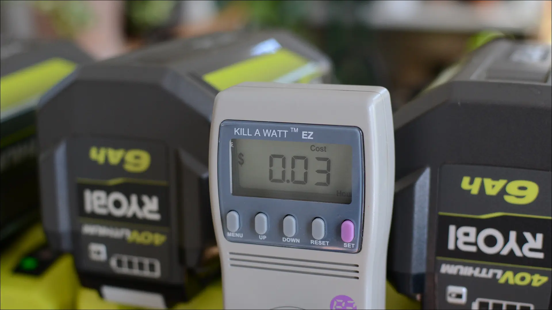 Vue rapprochée d'un compteur Kill A Watt chargeant des batteries Ryobi.