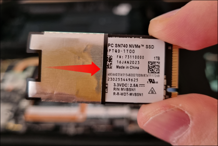 Pegang SSD baru dan pasang pelindung ESD di atasnya sampai benar-benar menutupi SSD tanpa port PCIe di bagian bawah