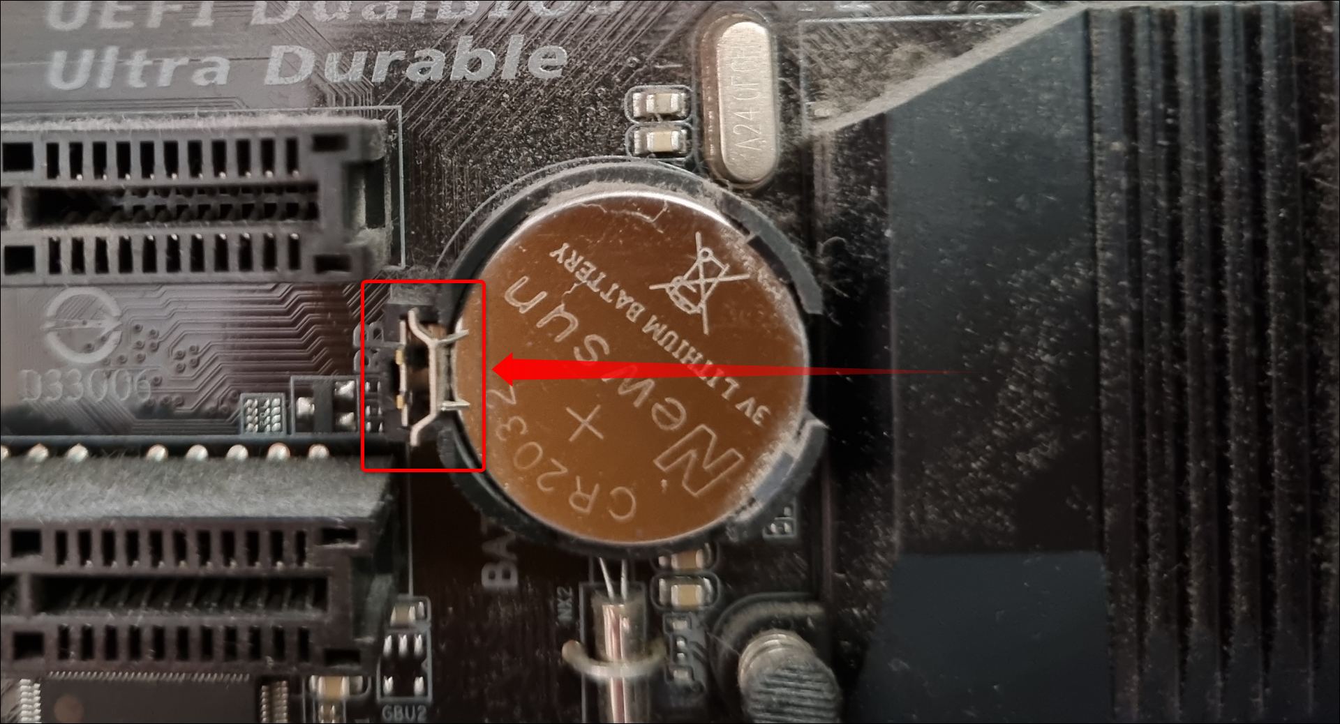 Um die CMOS-Batterie auszutauschen, müssen Sie mit den Fingernägeln oder einem Flachkopfschrauber auf den Riegel drücken und die Batterie herausnehmen